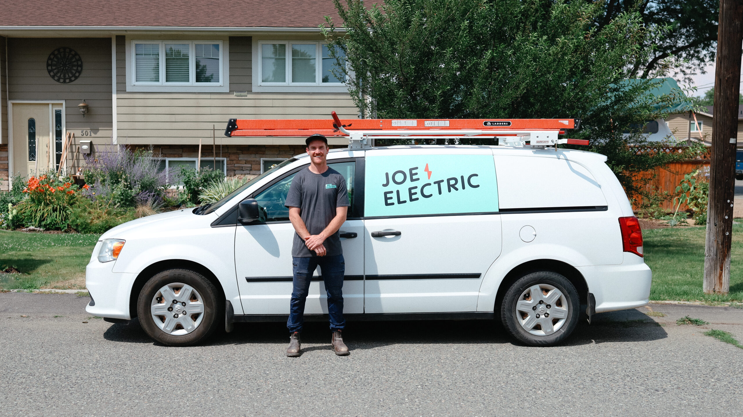 Joey Eddy, Owner of Joe Electric in Kamloops, BC poses in front of work van.